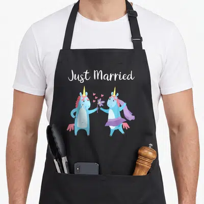 Tablier de cuisine noir avec deux licornes bleues et l'inscription Just Married en blanc.