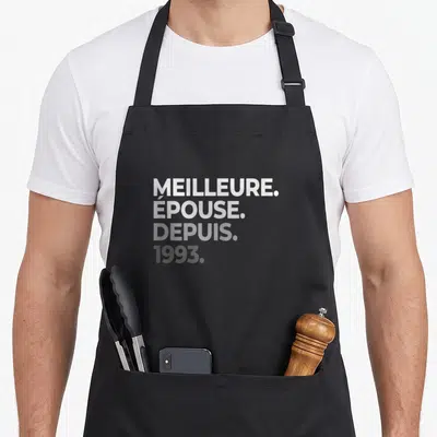 Tablier de cuisine noir avec le texte Meilleure Épouse Depuis 1993 imprimé en typographie blanche et grise sur le devant.