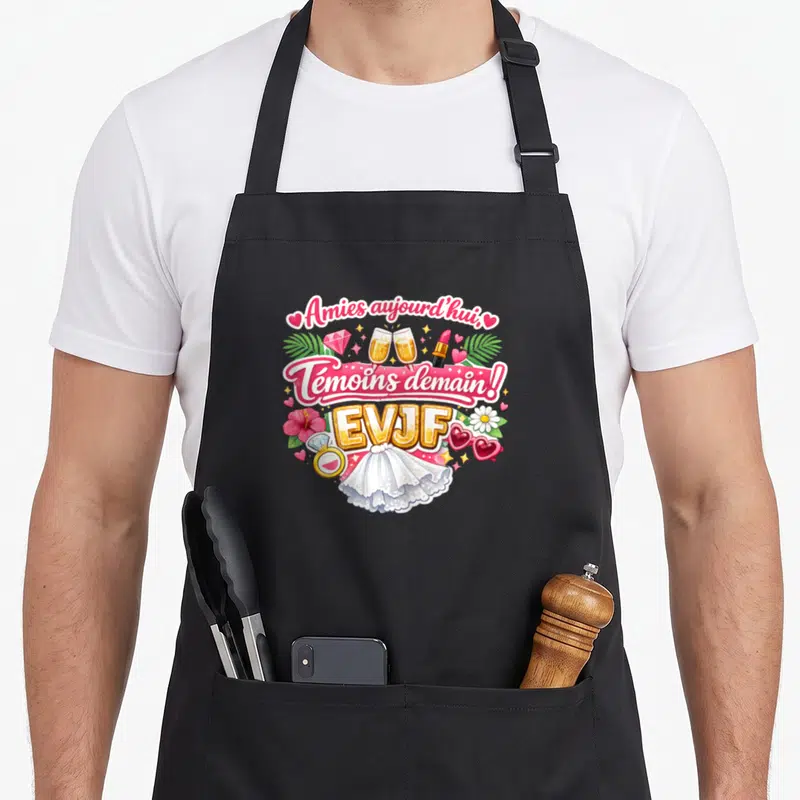Tablier de cuisine noir avec inscription Amies aujourd'hui Témoins demain EVJF entourée de champagne et de fleurs roses.