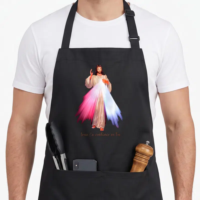 Tablier de cuisine noir avec une illustration du Divin Miséricorde et l'inscription Jésus j'ai confiance en Toi en bas.