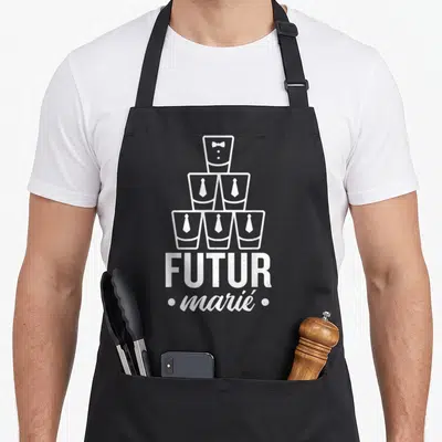 Tablier de cuisine noir avec une pyramide de verres et le texte Futur marié imprimé en blanc.