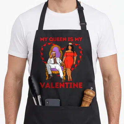 Tablier de cuisine noir avec illustration d'un couple royal et texte My Queen Is My Valentine en rouge.