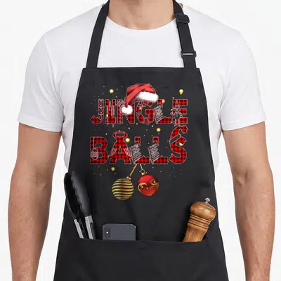 Tablier de cuisine noir avec inscription Jingle Balls Tinsel en carreaux rouges et décorations de Noël colorées.
