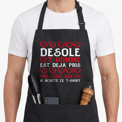 Tablier de cuisine noir avec inscription rouge et blanche Désole cet homme est déjà pris entouré de cœurs rouges dessinés à la main.