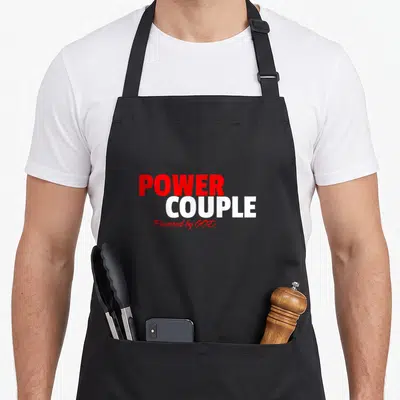 Tablier de cuisine noir avec l'inscription Power Couple Powered by God en rouge et blanc.