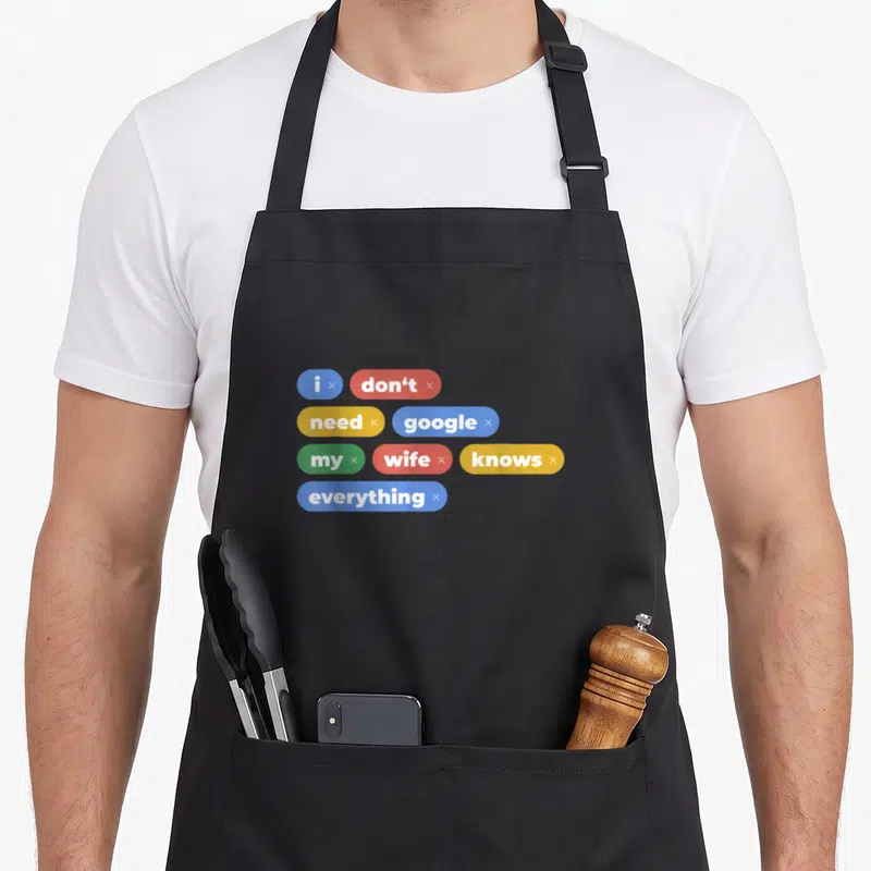 Tablier de cuisine noir avec des bulles colorées contenant le texte I don't need google my wife knows everything