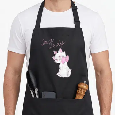Tablier de cuisine noir avec le portrait de Marie et l'inscription I'm A Lady en rose pastel.