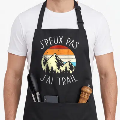 Tablier de cuisine noir avec illustration de montagnes et texte blanc Je peux pas j'ai trail.