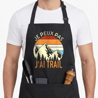 Tablier de cuisine noir avec illustration de montagnes et texte Je peux pas j'ai trail en style rétro.