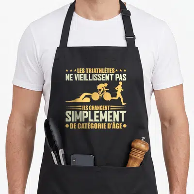 Tablier de cuisine noir avec silhouettes orange et texte blanc Les triathlètes ne vieillissent pas ils changent simplement de catégorie d'âge