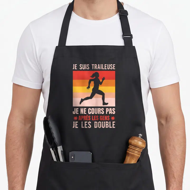 Tablier de cuisine noir avec silhouette de coureuse et texte humoristique sur fond de rayures colorées vintage.