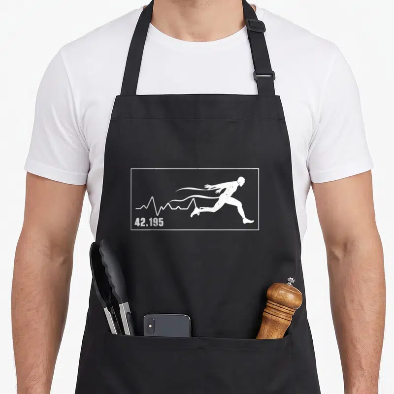 Tablier de cuisine noir avec silhouette blanche d'un coureur en action et la mention 42.195 intégrée à une courbe cardiacaque.
