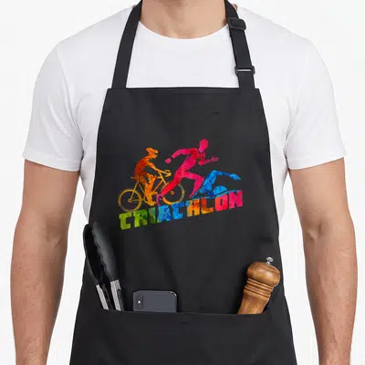 Tablier de cuisine noir avec silhouettes colorées de triathlètes et le mot triathlon en lettres texturées.