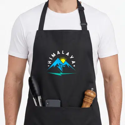 Tablier de cuisine noir avec logo montagne bleue soleil jaune texte Himalaya arc de cercle étoiles blanches reflet vert turquoise