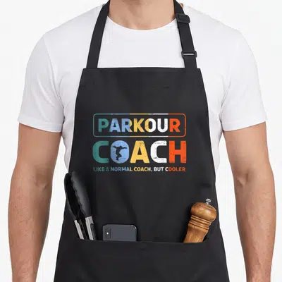 Tablier de cuisine noir avec inscription Parkour Coach et silhouette freerunner dans un style graphique coloré.