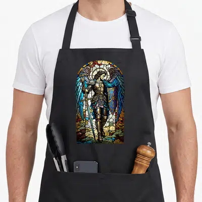 Tablier de cuisine noir avec illustration colorée style vitrail de Saint Michel Archange armé d'une lance et d'un bouclier.