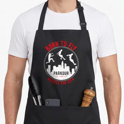 Tablier de cuisine noir avec logo circulaire Parkour, silhouettes blanches et texte rouge Born To Fly Across The City.