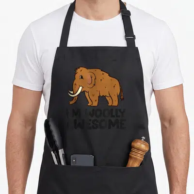 Tablier de cuisine noir avec illustration d'un mammouth brun et le texte I'M WOOLLY GÉNIAL imprimé en dessous.