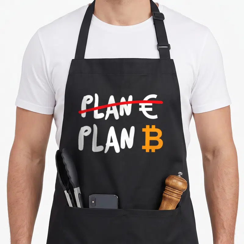 Tablier de cuisine noir avec inscription Plan « Euro » barré et logo Bitcoin orange en dessous.