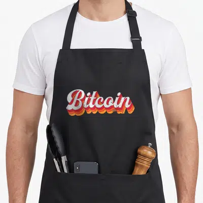 Tablier de cuisine noir avec linscription Bitcoin en lettres blanches et ombres orange style vintage années soixante.