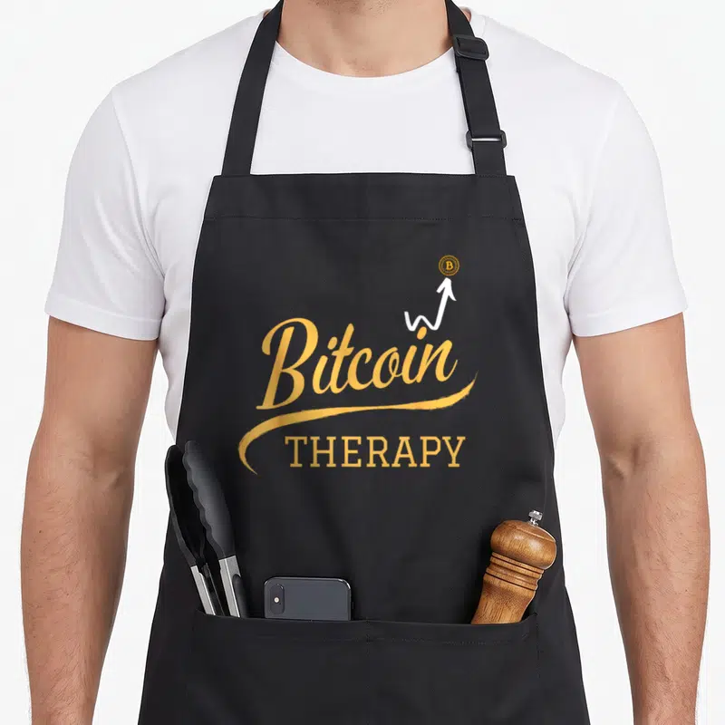 Tablier de cuisine noir avec linscription Bitcoin Therapy en orange et une flèche blanche pointant vers le haut.