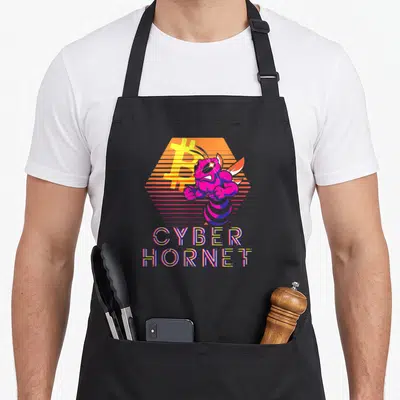 Tablier de cuisine noir avec illustration d'un frelon cybernétique rose et un logo Bitcoin orange sur fond hexagonal.
