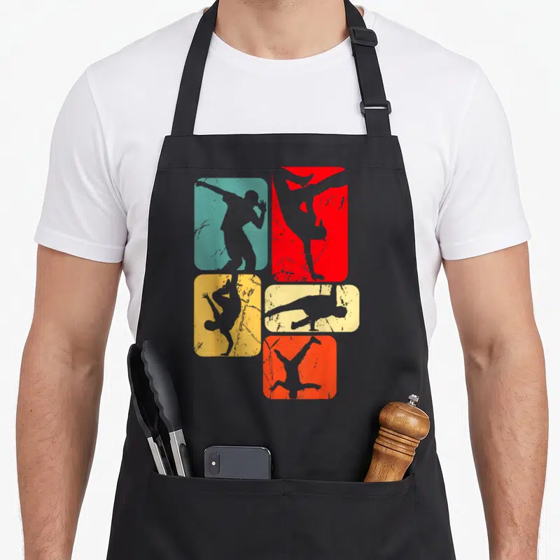 Tablier de cuisine noir avec cinq silhouettes de danseurs en mouvement sur fonds colorés.
