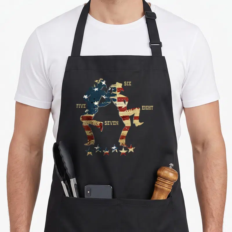 Tablier de cuisine noir avec deux silhouettes dansant en motif drapeau américain et les mots FIVE SIX SEVEN EIGHT.