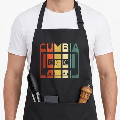 Tablier de cuisine noir avec illustration graphique de cassette audio colorée et texte stylisé CUMBIA LATINA en lettres géométriques.