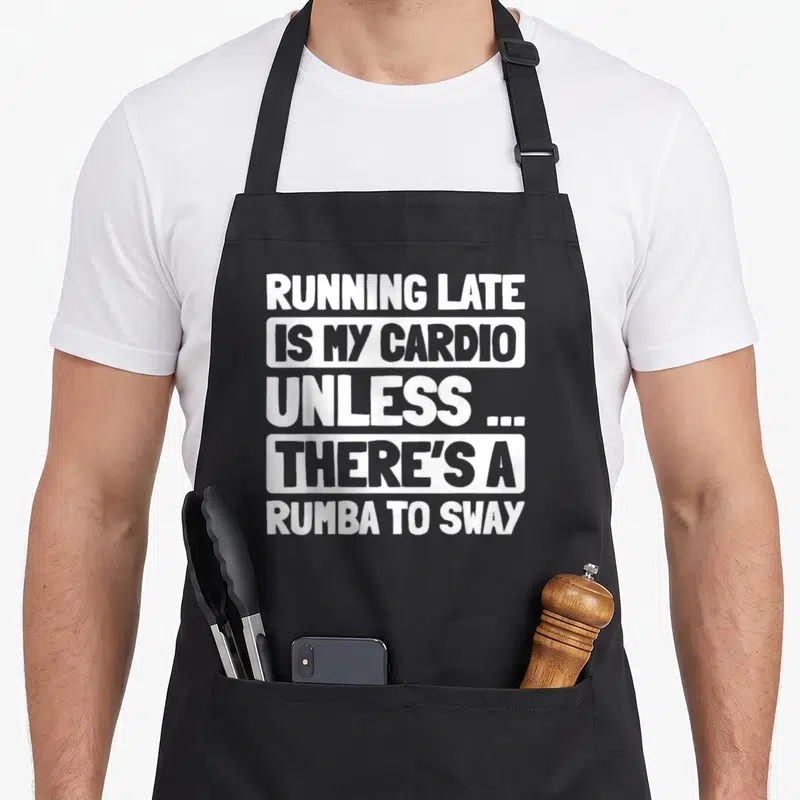 Tablier de cuisine noir avec inscription blanche Running Late Is My Cardio Rumba To Sway en lettres capitales.