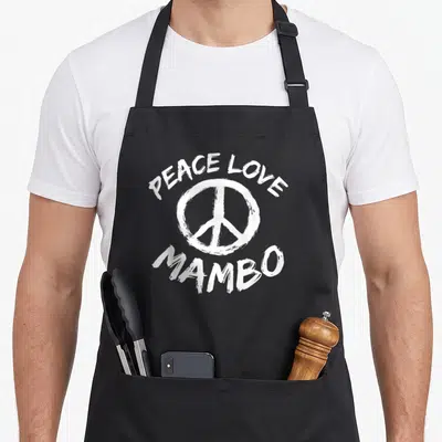 Tablier de cuisine noir avec inscription Peace Love Mambo et symbole de paix en blanc au centre du vêtement.