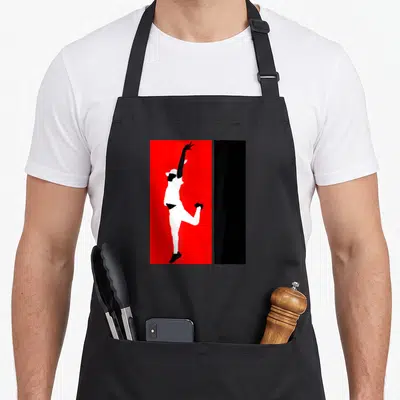 Tablier de cuisine noir avec silhouette blanche de danseur sur fond rouge vif, bras levé et chapeau.