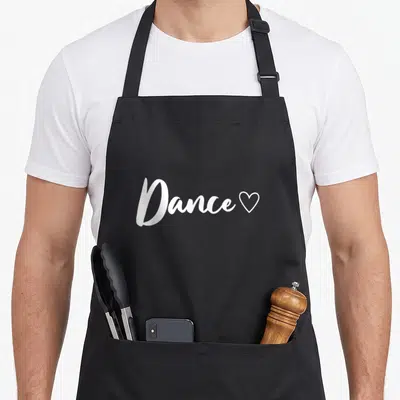 Tablier de cuisine noir avec inscription blanche Dance suivie d'un petit cœur stylisé.