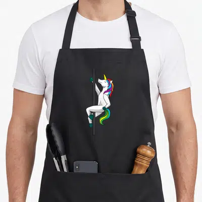 Tablier de cuisine noir avec une illustration de licorne blanche effectuant un pôle dance sur une barre noire.