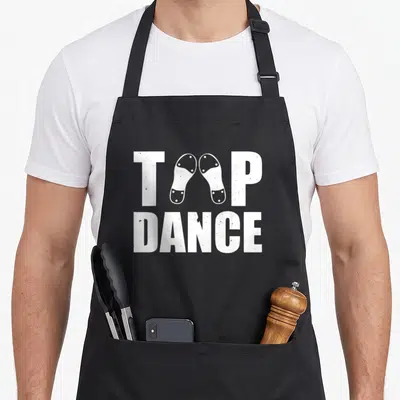 Tablier de cuisine noir avec inscription Tap Dance et illustration de chaussures à clous blancs.