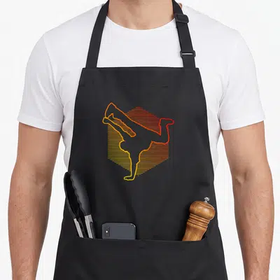 Tablier de cuisine noir avec silhouette de breakdancer aux lignes orange et jaune formant un cube géométrique.
