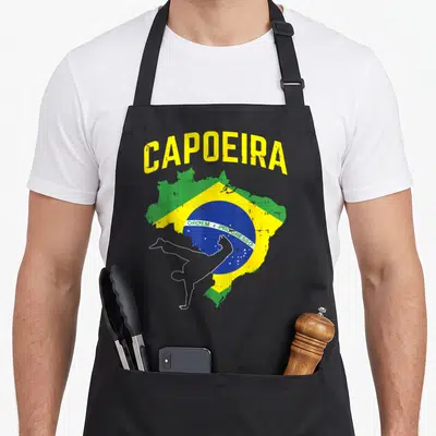 Tablier de cuisine noir avec carte du Brésil, drapeau et silhouette de capoeirista en blanc.