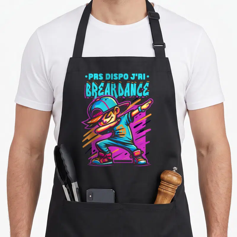 Tablier de cuisine noir avec illustration d'un garçon enfant breakdancer et texte PRS DISPO J'RI BREAKDANCE en lettres colorées.