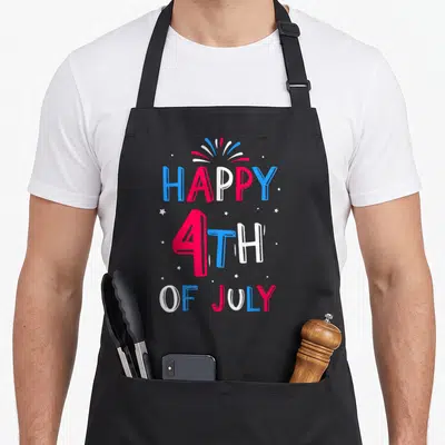 Tablier de cuisine noir avec inscription Happy 4Th Of July en lettres rouges bleues et blanches sur fond uni.