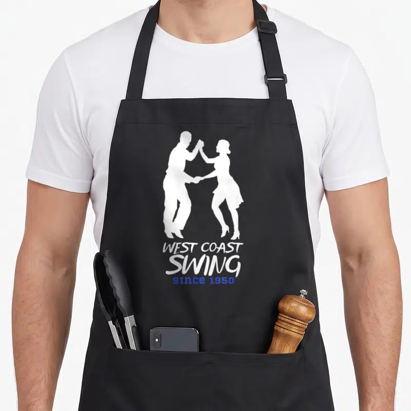 Tablier de cuisine noir avec silhouette blanche d'un couple dansant et texte West Coast Swing since 1950 en blanc et bleu.