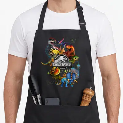 Tablier de cuisine noir avec un collage de dinosaures colorés et le logo Jurassic World au centre.