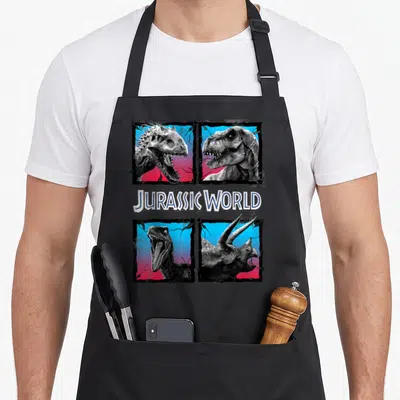 Tablier de cuisine noir avec quatre encadrés de dinosaures en noir et blanc sur fond dégradé rose et bleu.