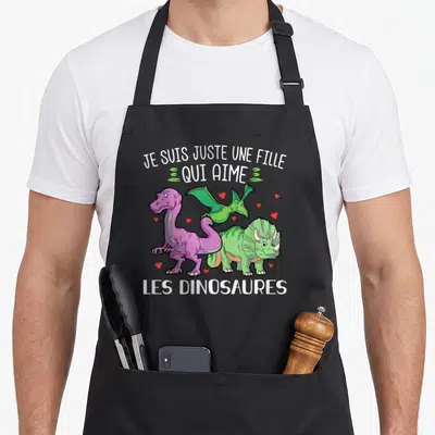 Tablier de cuisine noir avec trois dinosaures colorés et le texte Je suis juste une fille qui aime les dinosaures.