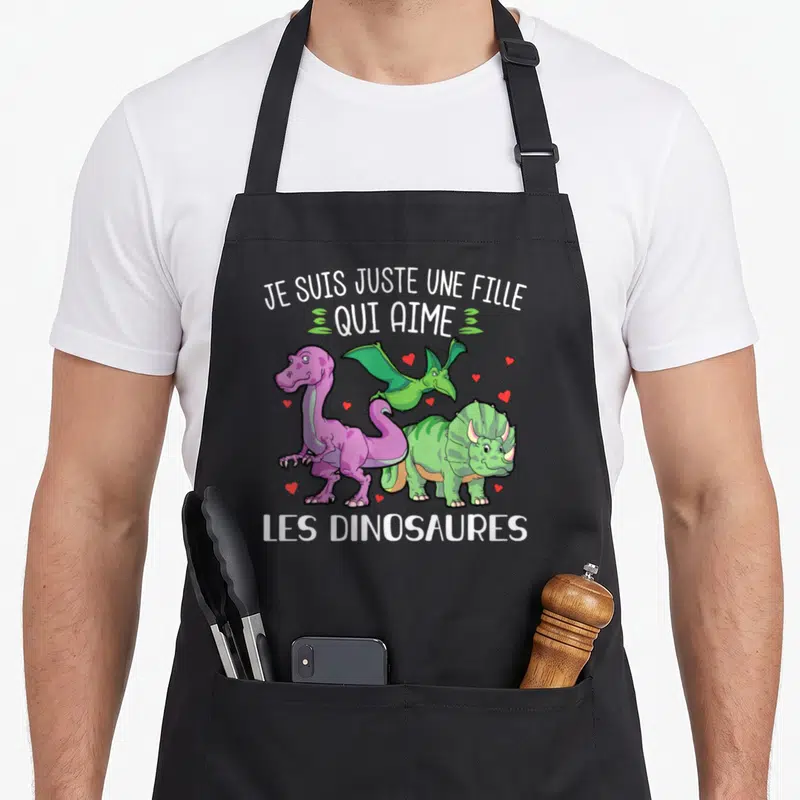 Tablier de cuisine noir avec trois dinosaures colorés et le texte Je suis juste une fille qui aime les dinosaures.