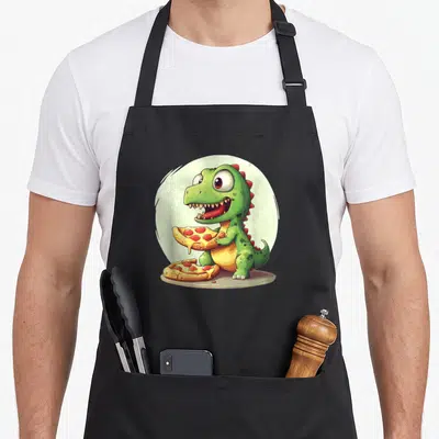 Tablier de cuisine noir avec illustration d'un petit dinosaure vert tenant une part de pizza au pepperoni.