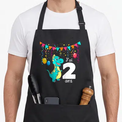 Tablier de cuisine noir avec dinosaure turquoise, guirlande de fêtes et inscription J'ai 2 ans en blanc.