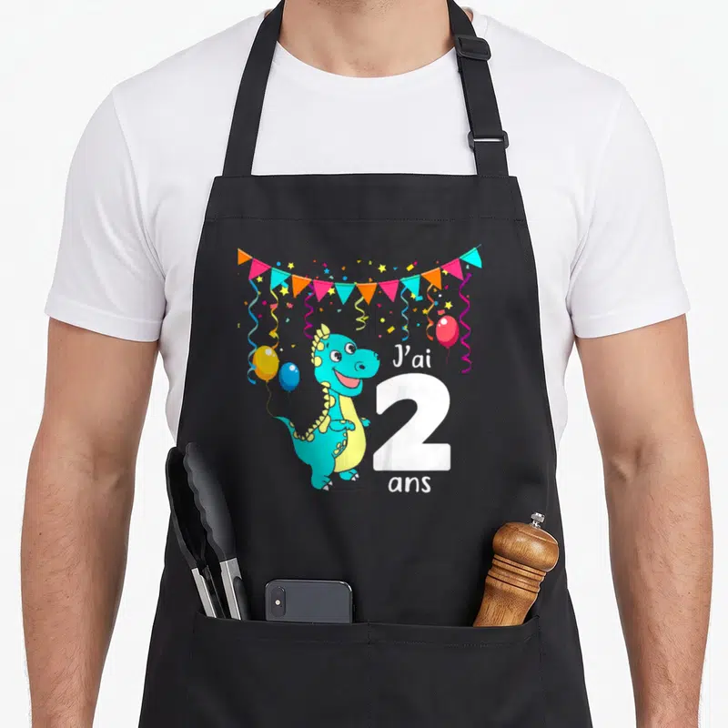 Tablier de cuisine noir avec dinosaure turquoise, guirlande de fêtes et inscription J'ai 2 ans en blanc.