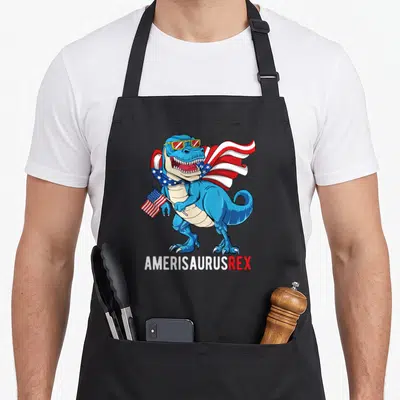 Tablier de cuisine noir avec un dinosaure bleu portant des lunettes de soleil et une cape aux étoiles américaines.