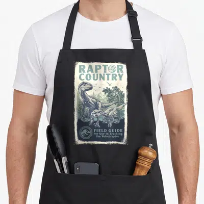 Tablier de cuisine noir avec illustration vintage Raptor Country Field Guide représentant deux dinosaures.