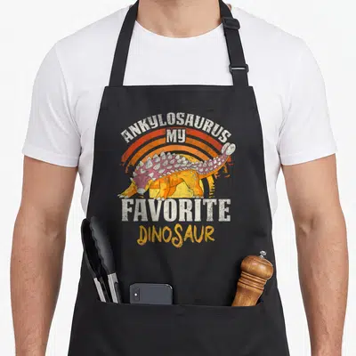 Tablier de cuisine noir avec illustration d'Ankylosaurus orange et texte My Favorite Dinosaur en style vintage.